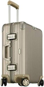 A beige suitcase with wheels on a white background.